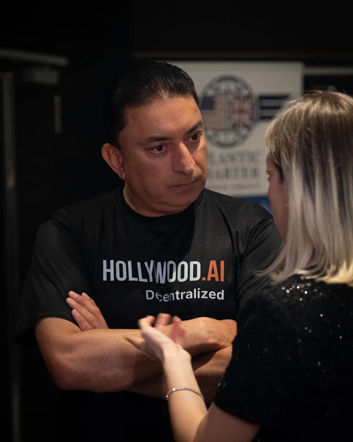 Sheeraz Hasan in a Hollywood.AI shirt, in conversation at an event